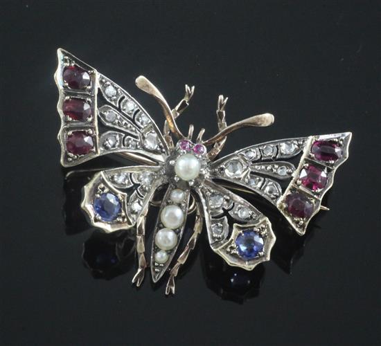 A Victorian style gold and silver, ruby, sapphire, split pearl and rose cut diamond set butterfly brooch, 37mm.